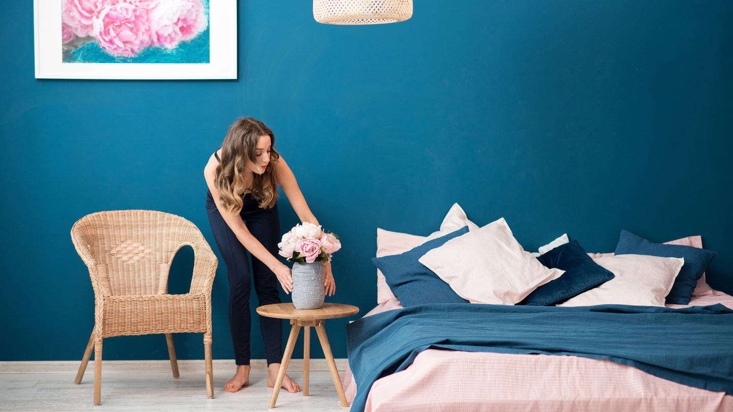 A woman arranging her room.