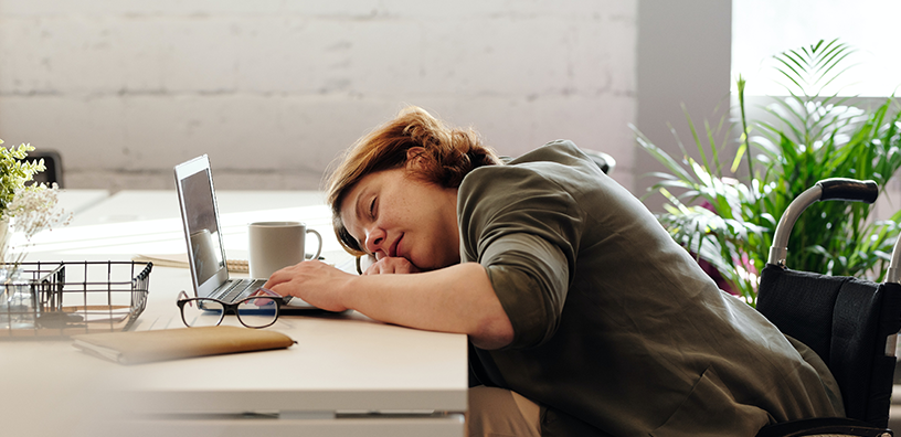 A woman sleeping on her desk.