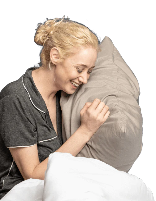 A woman embraces a Cosy House Collection Luxury pillow, radiating comfort and relaxation.
