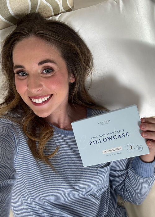 Woman holding a pillowcase packaging in bed