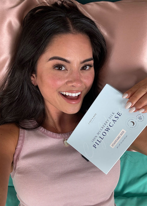 Woman holding a silk pillowcase box with a pillow in the background