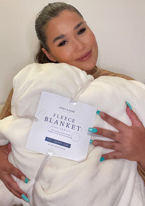 A customer hugging her Everyday Fleece Blanket.