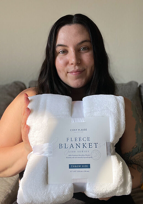 A customer displaying her Everyday Fleece Blanket.