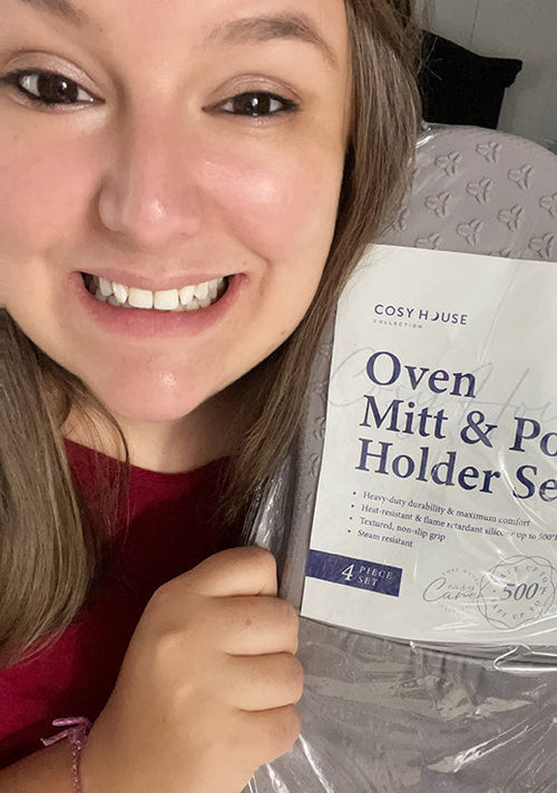 An excited customer flexing her packaged Cosy House Collection’s Oven Mitt & Pot Holder Set.
