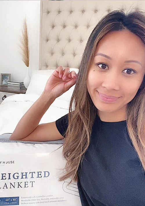 A smiling customer flexes her packaged Weighted blanket.