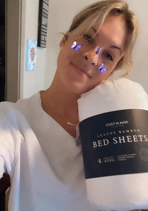 Another happy customer holding a packaged set of Cosy House Collectionâs Luxury bed sheets.