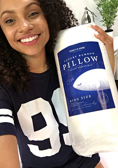 A happy female customer is holding a packaged Cosy House Collection Luxury pillow.