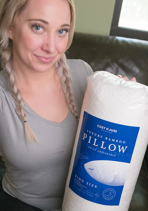 Another female customer is holding a packaged Cosy House Collection Luxury pillow.