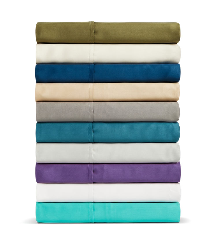 A stack of Cosy House Collection pillowcases in various colors.