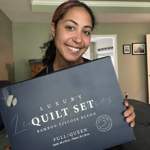 A smiling customer showing her Luxury Quilt set.
