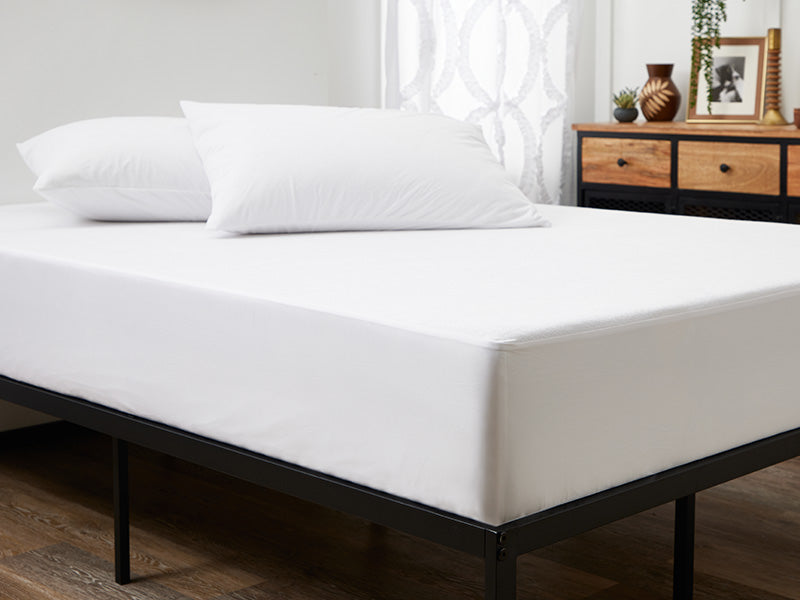 A neatly made bed featuring Cosy House Collection’s Luxury Mattress Protector, perfect for a restful night's sleep.