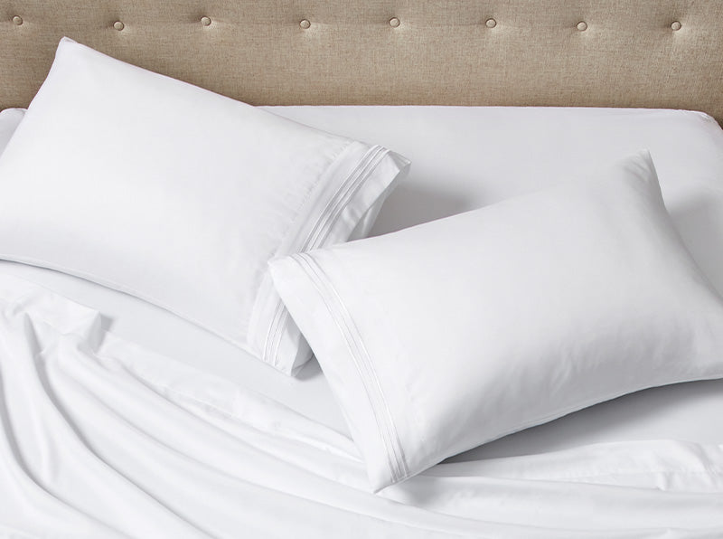 A pair of pillows on the bed covered with Everyday pillowcases.