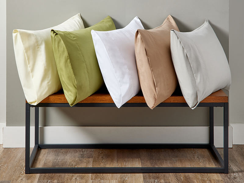 A bench adorned with five colorful pillows.