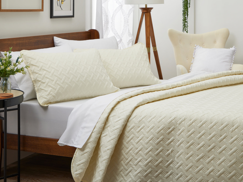 A neatly arranged bed with Cosy House Collection bedding.