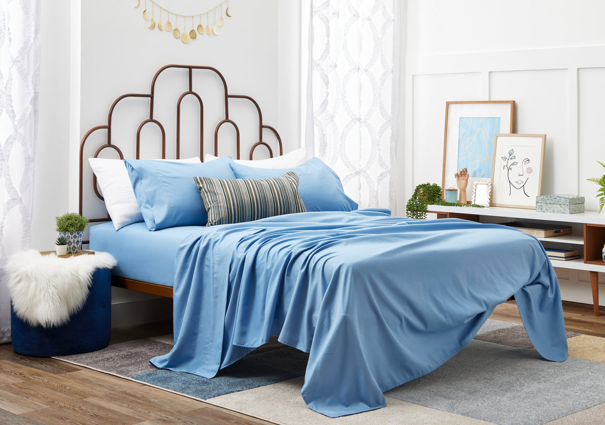 Blue sheets on a bed 2nd angle