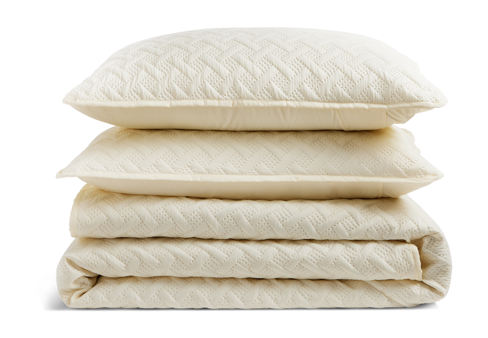 A stack of a folded quilt and two pillow shams.