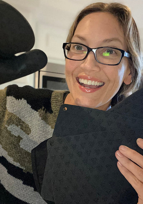 A happy customer flexing her unpacked Cosy House Collection’s Oven Mitt & Pot Holder Set.